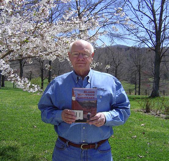 Charles Hill posing with his book, "Blood Mountain Covenant"